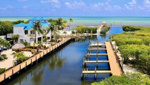 Un canal avec un quai, un bâtiment doté d’un toit bleu et une plage en arrière-plan.