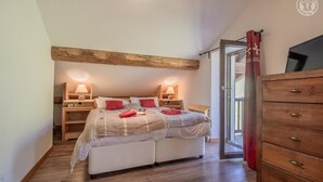 A bedroom with a bed, bedside tables, a dresser, and a window with curtains. - Residence Mont- Blanc Lodge - LA Fleche (HAUTELUCE)