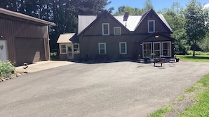 Een tweelaags huis met een garage, een overdekt terras en een oprit.