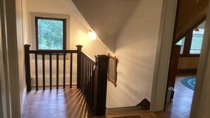 Een trap met houten leuningen, een houten handrail en een vloerkleed aan de onderkant.