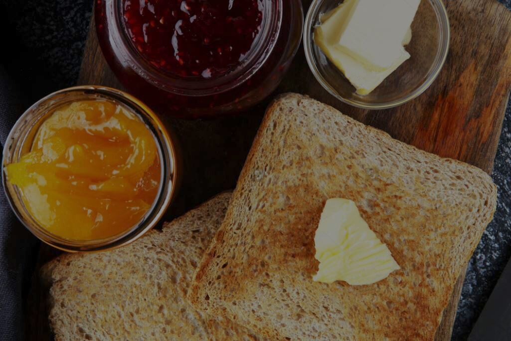 Two slices of whole grain toast with butter and jam.