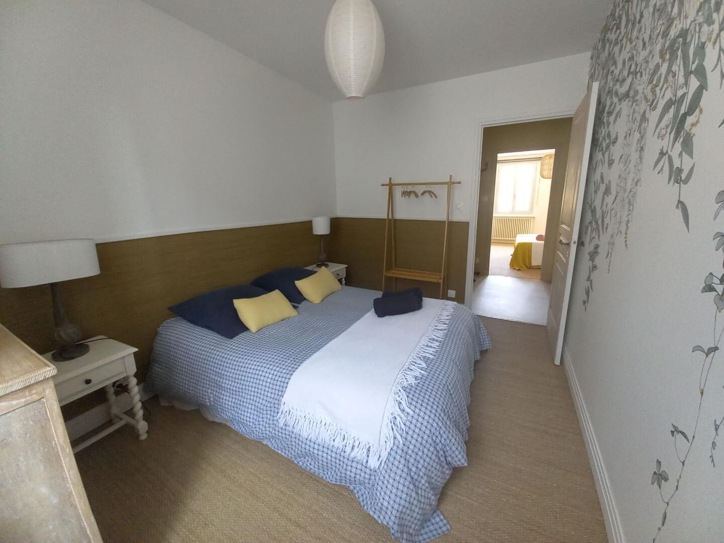 Un dormitorio con cama, mesita de noche, lámpara y armario.