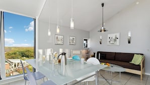 A modern kitchen with a glass dining table, two chairs, a brown sofa, and a view of the outdoors. - Awesome apartment in Fanø with WiFi (Fanø)