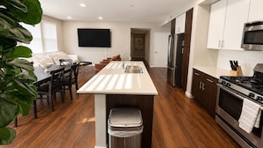 A modern kitchen with a central island, stainless steel appliances, and a dining area with a sofa and chairs. - Spacious 3 Bedroom, Close Venice Beach (Marina del Rey)