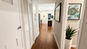 A hallway with wooden flooring, white doors, and a framed artwork on the wall. - Spacious 3 Bedroom, Close Venice Beach (Marina del Rey)