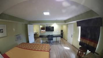Une chambre d’hôtel équipée d’un lit, d’un bureau, d’une chaise et d’un téléviseur.