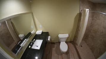 Een badkamer met een zwarte wastafel, een wit toilet en een douchegedeelte.