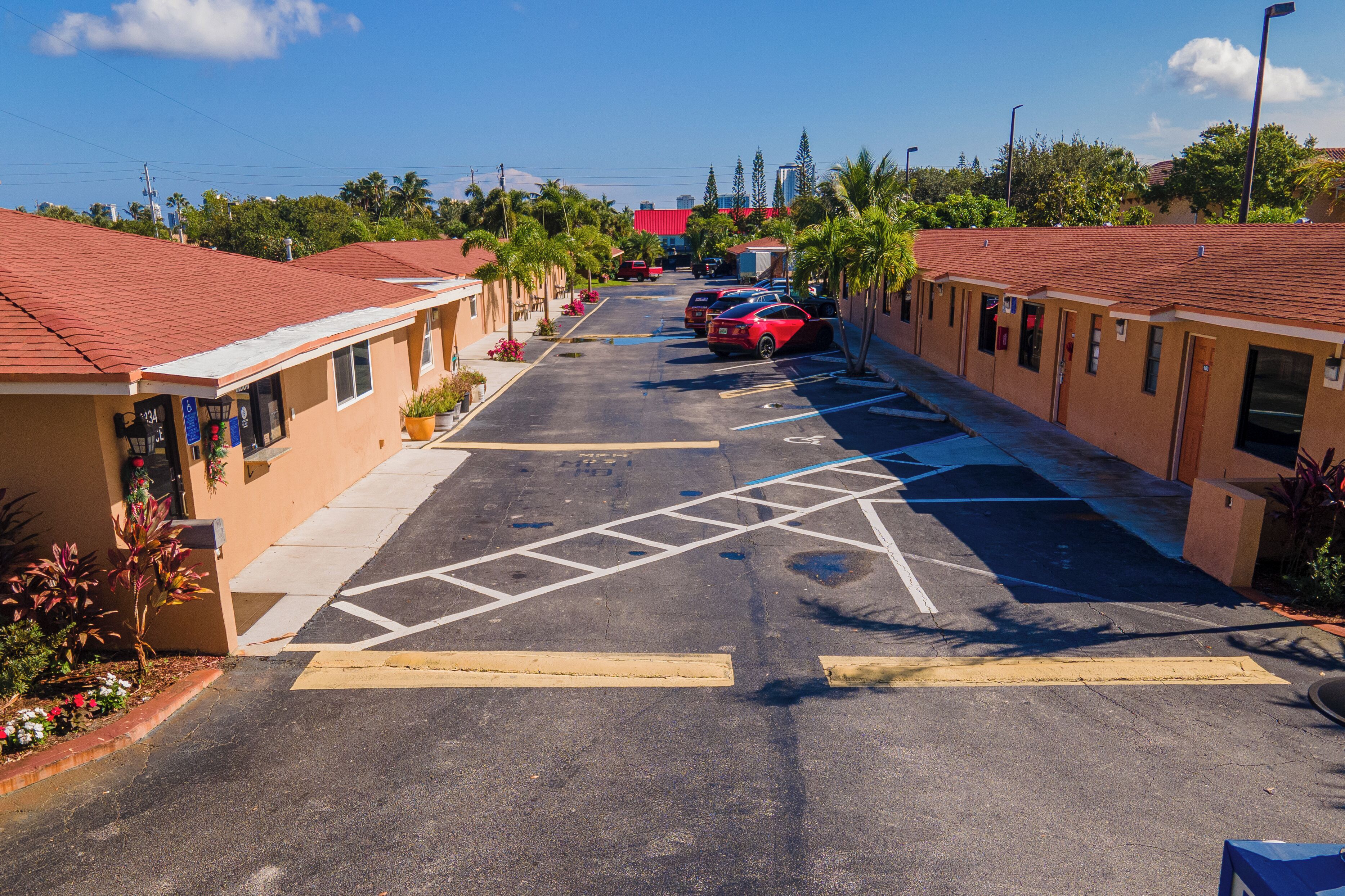 A row of single-story buildings with a parking lot in front.