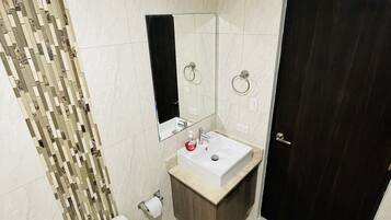 Un baño moderno con inodoro, lavabo y espejo.