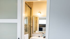 Un baño de hotel con lavamanos blanco, espejo y toallero.