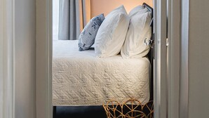 A bedroom with a bed, curtains, a wall-mounted light fixture, and a bedside basket. - 3 BLK Walk to Funky DT Ferndale's Restaurants & Bars/20 Min Drive to DT Detroit (Ferndale)