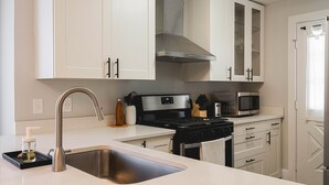 A modern kitchen with white cabinetry, stainless steel appliances, and a built-in microwave. - 3 BLK Walk to Funky DT Ferndale's Restaurants & Bars/20 Min Drive to DT Detroit (Ferndale)