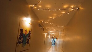 A corridor with string lights, a framed picture on the wall, and a tiled floor. - La Quinta Loft Apartments (Iquitos)