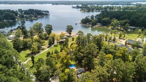 A residential area with a large lake, surrounded by dense trees and multiple houses.