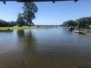Ein ruhiger See mit einem Steg und einer Rasenfläche.