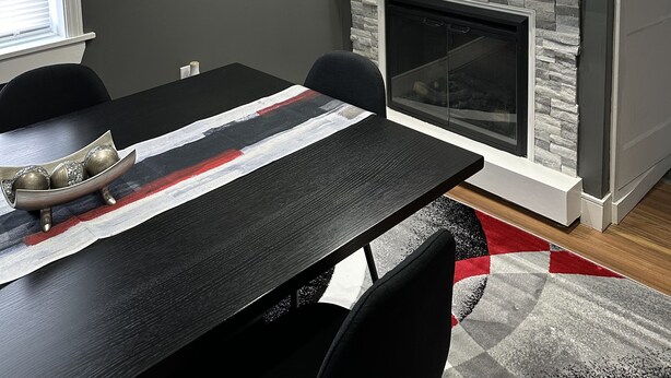 A modern dining room with a fireplace, a dining table, and chairs.