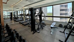 A gym with treadmills, weight machines, and dumbbells. - APARTAMENTO ALTO LUXO (Recife)