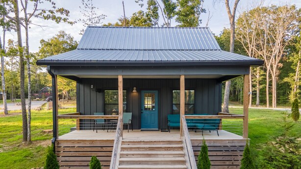 A wooden cabin with a porch, a blue door, and a metal roof. - Sparks Fly / The Retreat at Water's Edge / 2 Kayaks, 1 Canoe, 1 Paddle Board (Tracy City)