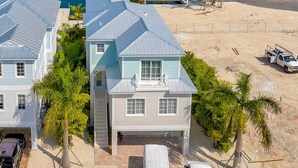 Um imóvel à beira-mar com duas casas, piscina e vista para a praia.