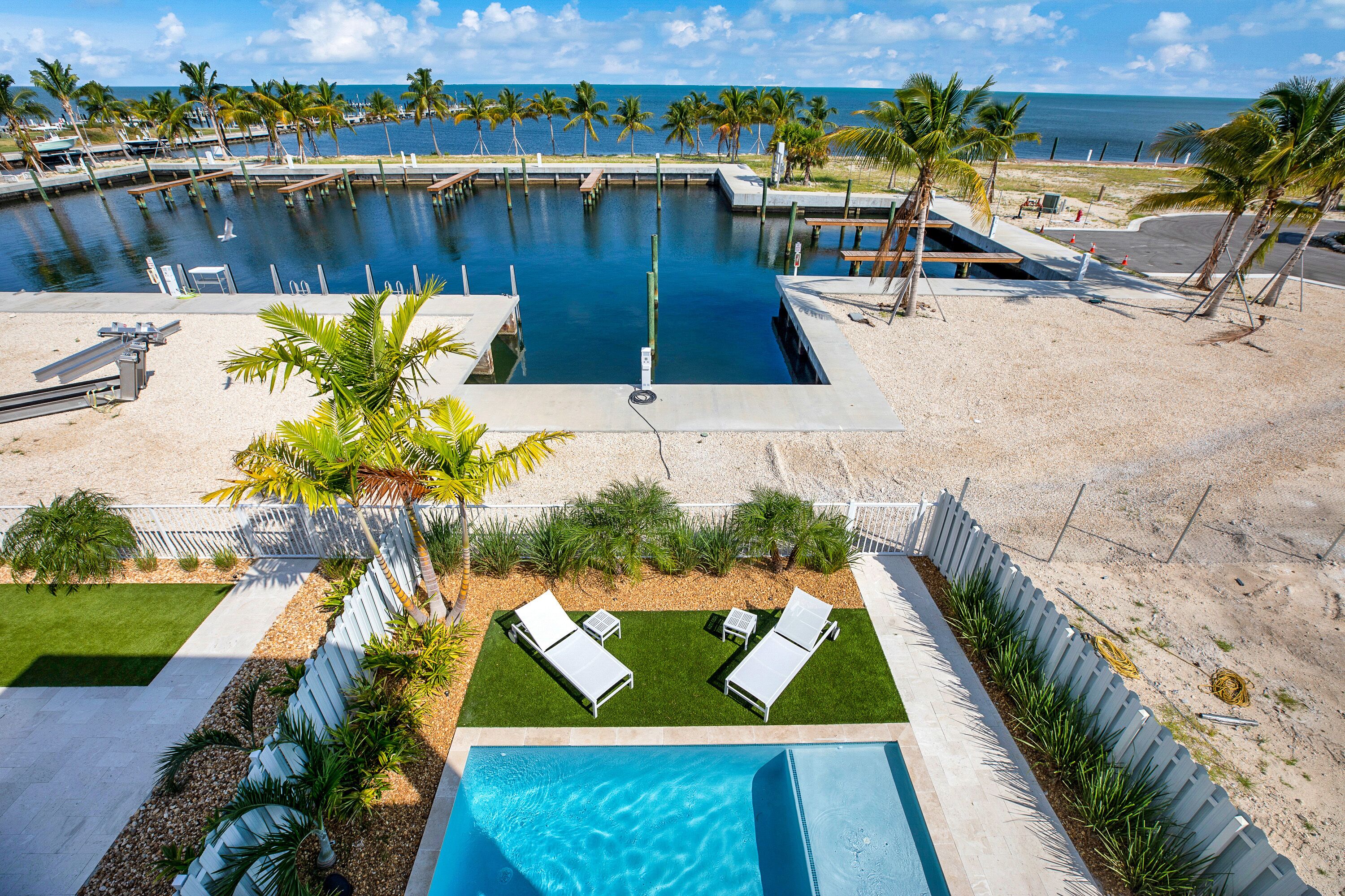 Un espace piscine avec vue sur l’océan, des chaises longues et une petite piscine.
