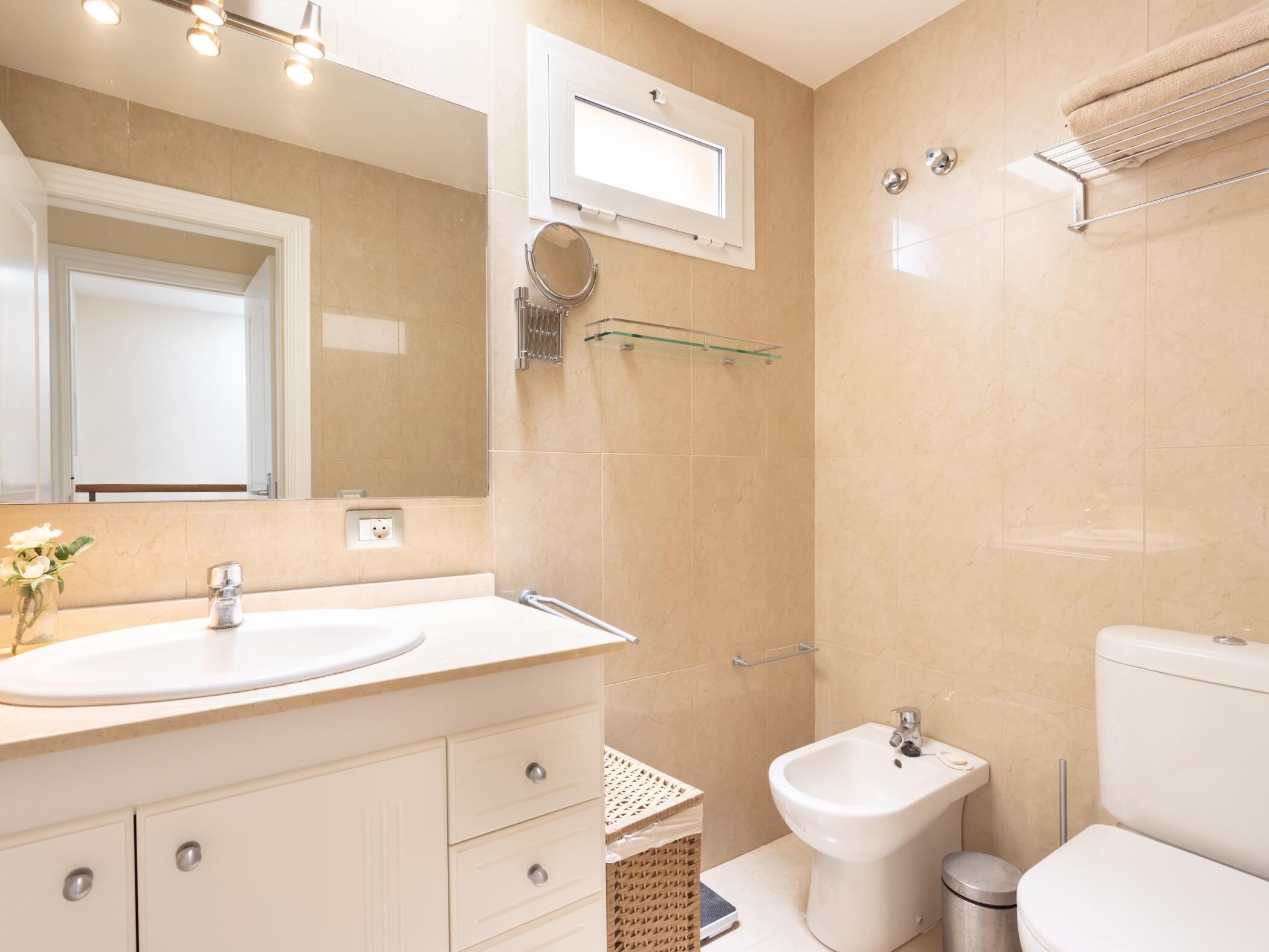 Un bagno moderno con lavandino, specchio, bidet e WC.