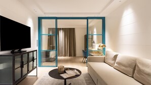 A modern living room with a flat-screen TV, a sofa, a coffee table, and a glass partition. - Chayofa Suites - Deluxe (Santa Cruz de Tenerife)