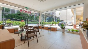 Un intérieur moderne avec des coins salon, de grandes fenêtres et des plantes en pot.