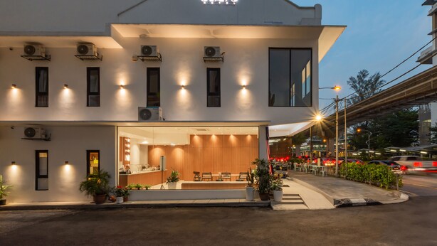 Un hôtel moderne doté d’une entrée bien éclairée, d’un espace extérieur aménagé et d’un comptoir de réception bien visible.