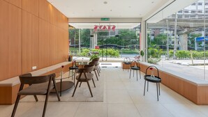 Un espace d’attente moderne avec des panneaux de bois, des cloisons en verre et une vue sur la rue.