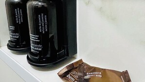 A bathroom shelf with black toiletries and a brown soap bar. - Nomad - Norte Sul, Cambui (Campinas)