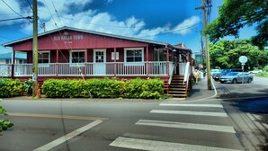 Ein rotes Gebäude mit einer weißen Veranda und einem Schild, auf dem 'Old Koloa Town' steht.