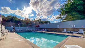 Une piscine avec des chaises longues et un espace abrité.