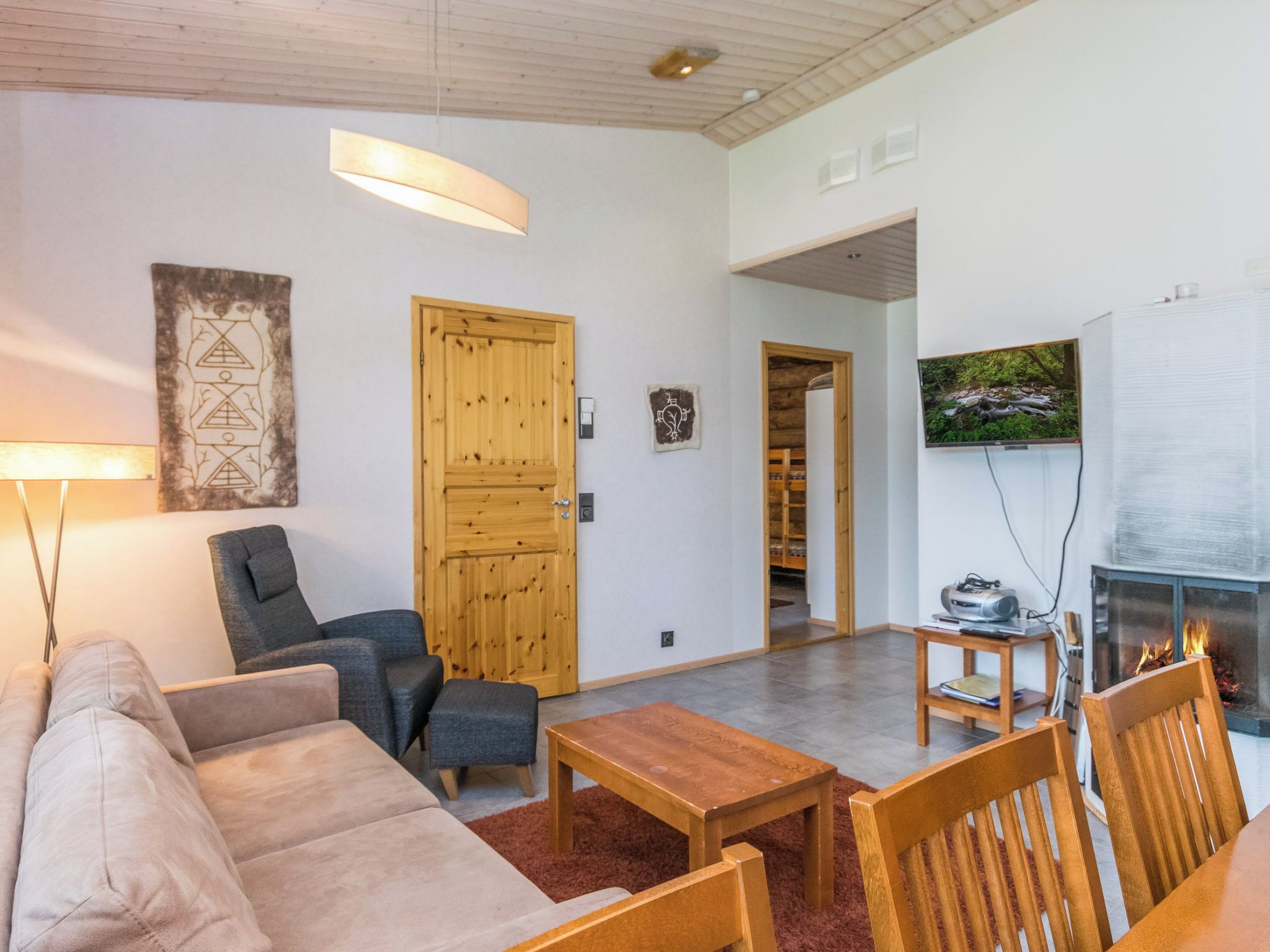 Un salon moderne avec un canapé, des fauteuils, une table basse et une cheminée.