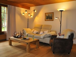 A cozy living room with a sofa, a coffee table, a lamp, and a chair.