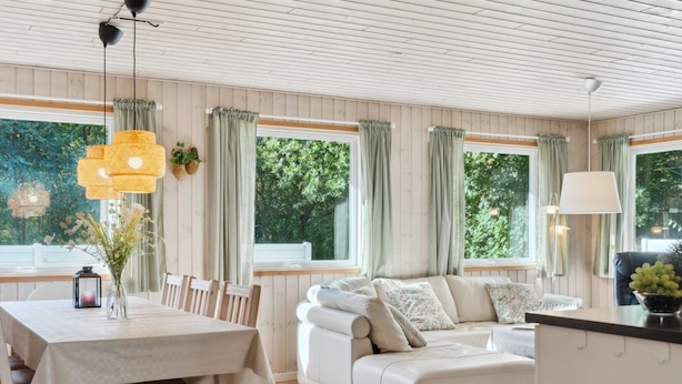 A cozy room with a dining table, a sofa, and a window with curtains. - "Viljo" - 30km from the sea by Interhome (Toftlund)
