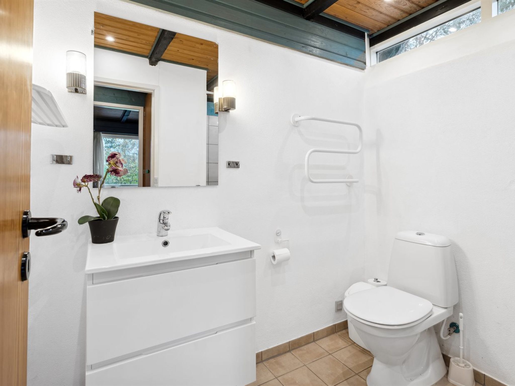 Een moderne badkamer met een wit wastafelmeubel, een toilet en een douchehoek.