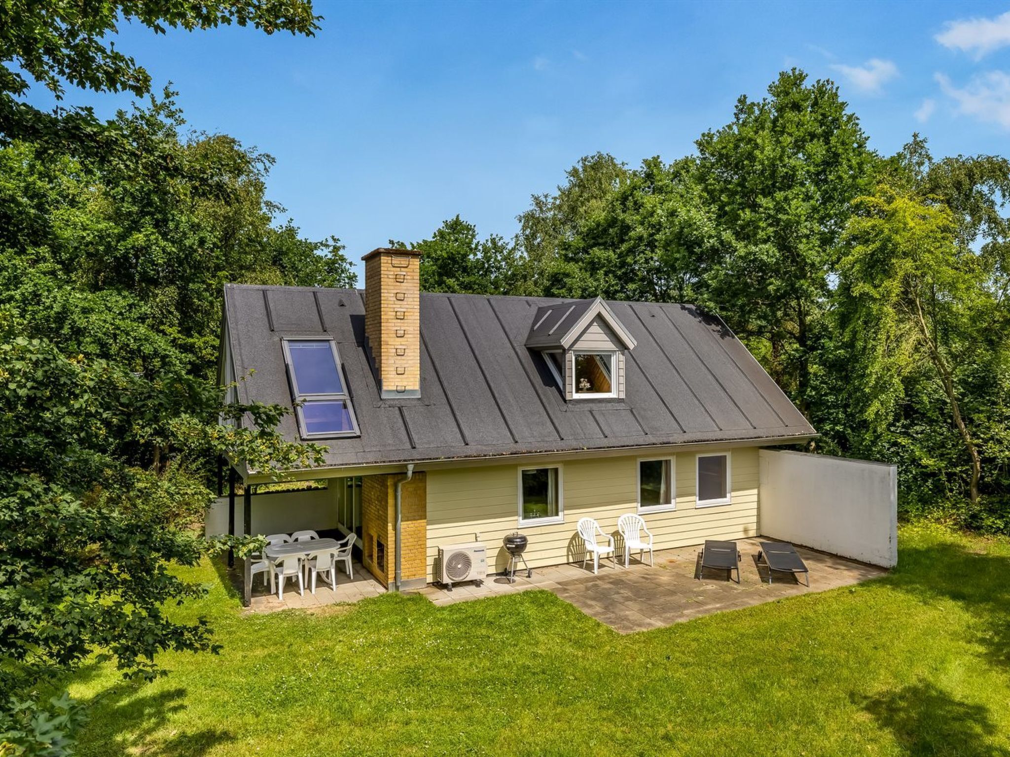 A single-story house with a sloped roof, a chimney, and a small attached garage.