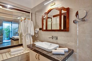 Sink, mirror, and glass-enclosed shower area in a luxurious bathroom setting.