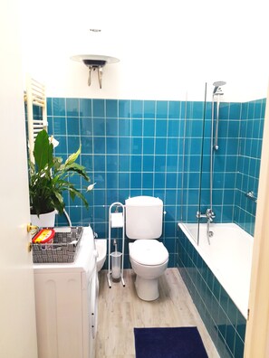 A bathroom with blue tiles, a white toilet, a bathtub, and a shower. - Palocco Boutique (Lazio)