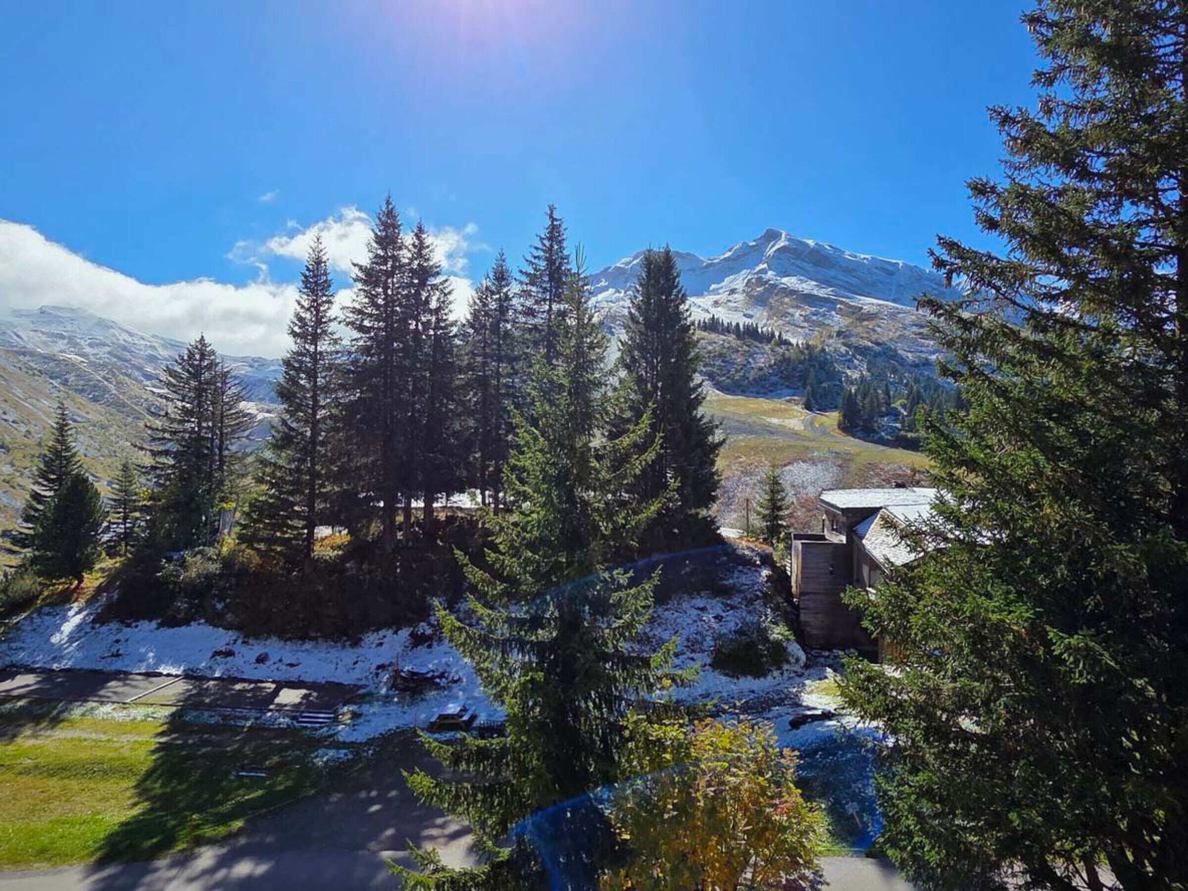 Un albergue de montaña con vistas despejadas a un pico nevado al fondo.