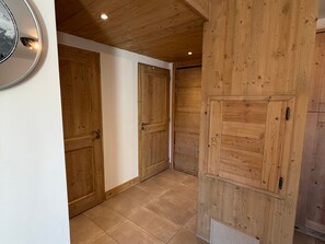 Ein Korridor mit Holztüren und Fliesenboden.