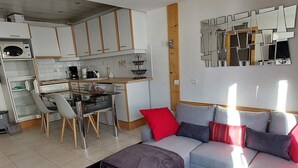 A compact living space with a kitchenette, a dining area, and a seating area with a sofa and a coffee table. - Modern apartment for 5 in the heart of Avoriaz (Avoriaz)