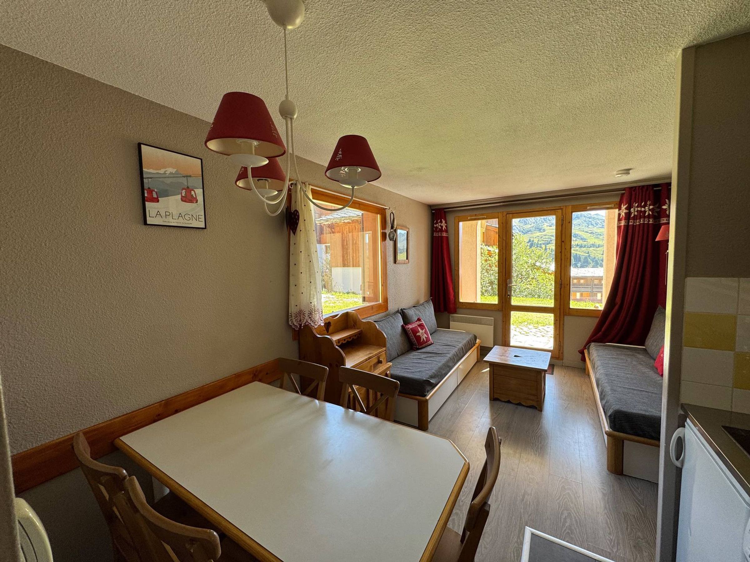 A cozy living room with a sofa, a dining table, and a kitchen area.