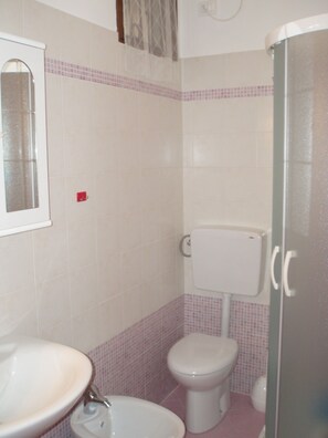 Ein Badezimmer mit Waschbecken, Toilette und Dusche.