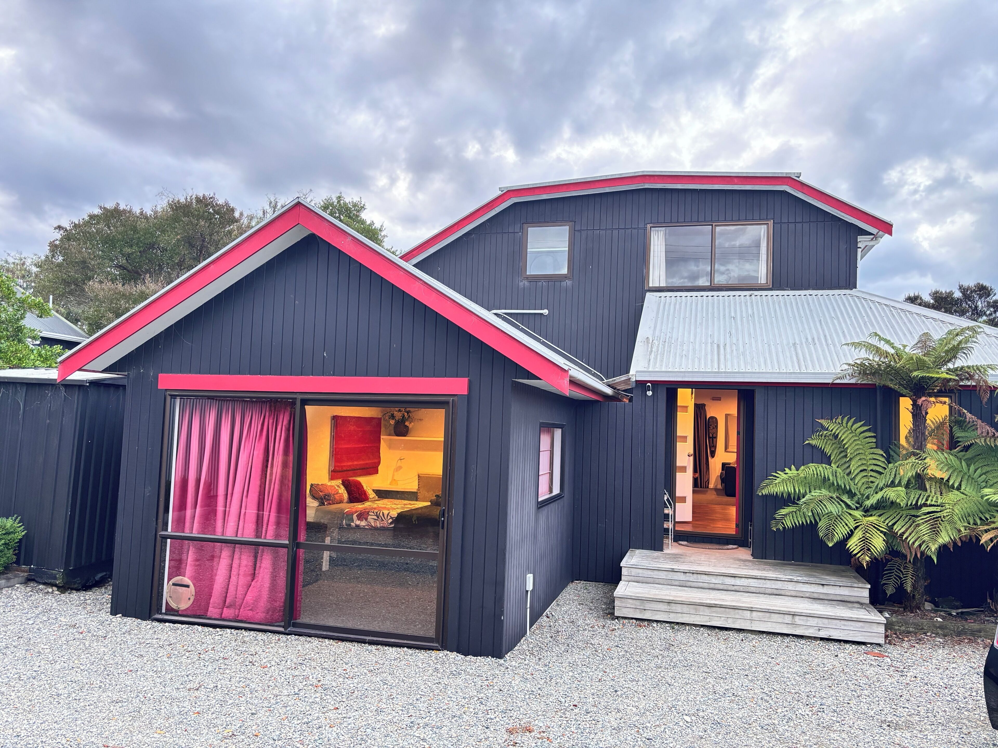 A two-story building with a red roof and a large sliding glass door.