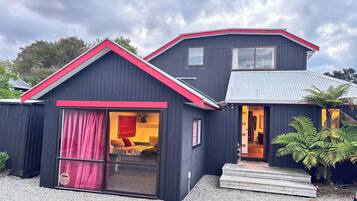 A two-story building with a red roof and a large sliding glass door.