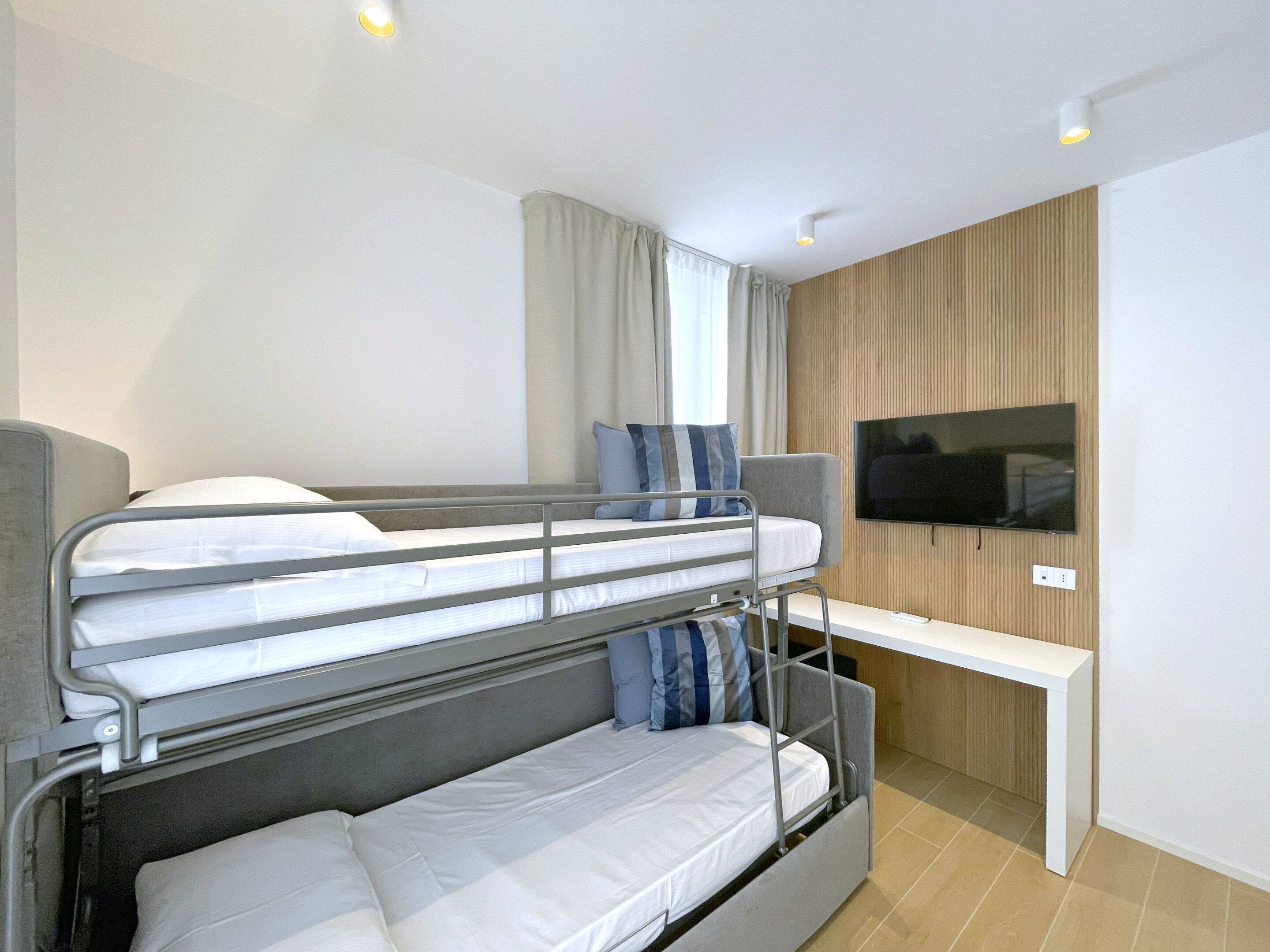 Habitación con literas, televisión y escritorio.