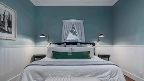 A bedroom with a bed, bedside tables, a canopy, and a framed picture on the wall. - Stonewall Main Haus - Sleeps 6 (Stonewall)
