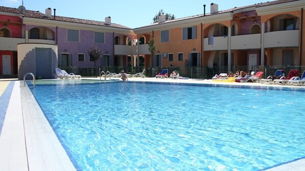 Relax by the pool surrounded by comfortable lounge chairs and take in the views of the Mediterranean-style building.