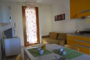 Cozy living space with a kitchenette, dining table, and comfortable sofa.